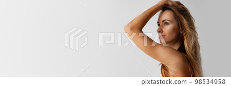 Portrait of beautiful woman with blonde hair posing over grey background. Taking care after skin and hair. Banner, flyer. Concept of skin care, cosmetology Portrait of beautiful woman with blonde hair posing over grey background. Taking care after skin and hair. Banner, flyer. Concept of skin care, cosmetology 98534958