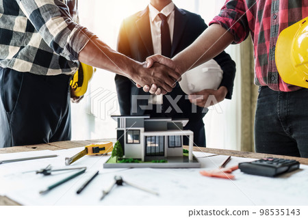 Engineer and businessman shake hands as they divide the tasks after a successful deal at the office Engineer and businessman shake hands as they divide the tasks after a successful deal at the office 98535143