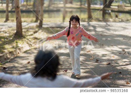 Asian Grandmother and Granddaughter hug together outdoor park. Hobbies and leisure, lifestyle, family life, happiness moment concept 98535168