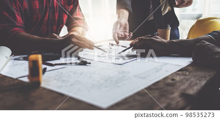 Close up of Architect team working with house model for architectural plan, engineer sketching a construction project, green energy concept Close up of Architect team working with house model for architectural plan, engineer sketching a construction project, green energy concept 98535273