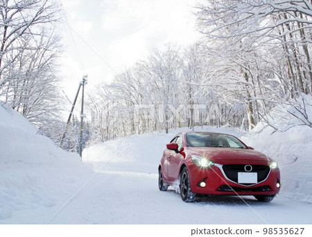 Image of a winter drive: a snowy mountain road and a compact car Image of a winter drive: a snowy mountain road and a compact car 98535627