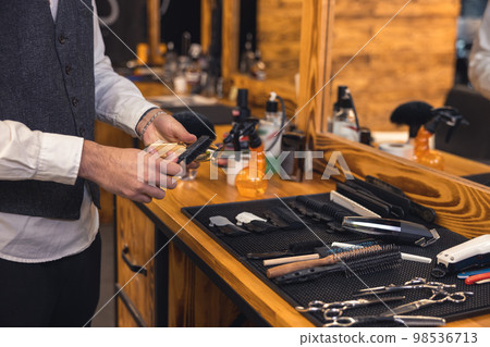 Barber with hairdressing tools an the barbershop 98536713