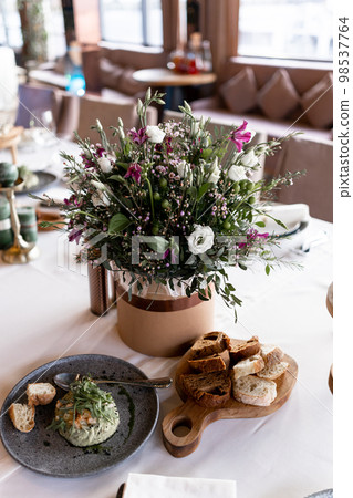 food and decoration of flowers on a festive table in a restaurant food and decoration of flowers on a festive table in a restaurant 98537764