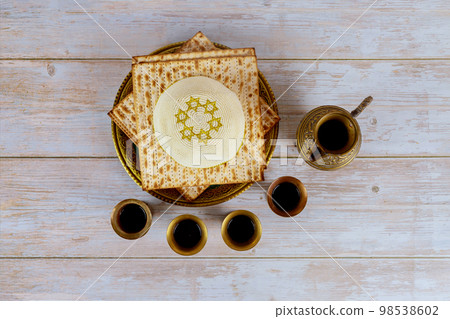 During Passover Jewish holiday celebration, matzoh is served as accompanied by kiddush four cups red kosher wine During Passover Jewish holiday celebration, matzoh is served as accompanied by kiddush four cups red kosher wine 98538602