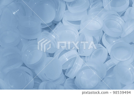 The pile of clear plastic bottle caps. 98539494