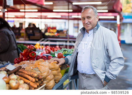 Middle aged man buying vegetables 98539526