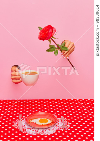 Food pop art photography. Female hand sticking out pink paper with coffee cup and rose flower. Fried eggs for breakfast 98539614