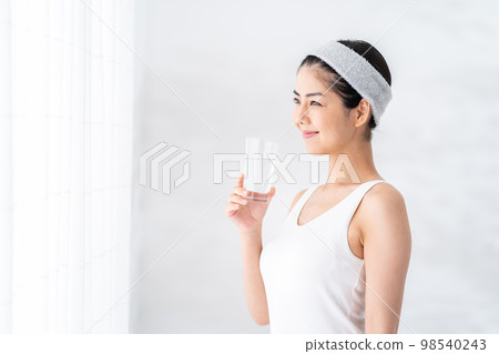 一個女人在窗邊喝水。 98540243