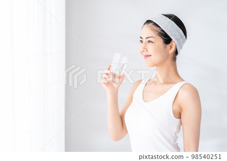 一個女人在窗邊喝水。 一個女人在窗邊喝水。 98540251