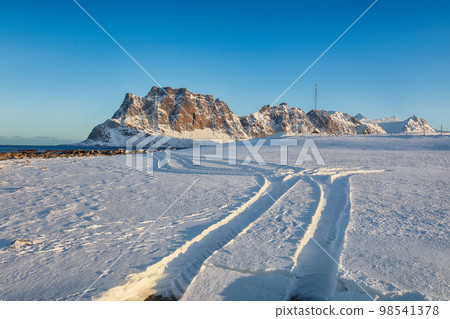 Fantastic winter scenery on Uttakleiv beach at morning with car tracks Fantastic winter scenery on Uttakleiv beach at morning with car tracks 98541378