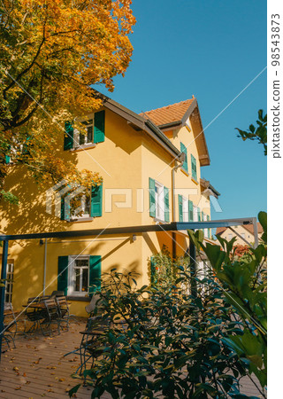 Image of a empty coffee tables arranged in backyard of a house. Autumn in Germany, Europe. Outdoor table in street cafe. autumn outdoor cafe wooden furniture old europe. Autumn photo of old-fashioned Image of a empty coffee tables arranged in backyard of a house. Autumn in Germany, Europe. Outdoor table in street cafe. autumn outdoor cafe wooden furniture old europe. Autumn photo of old-fashioned 98543873
