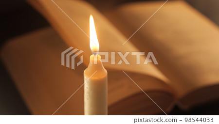A Burning Candle and an Old Book A Burning Candle and an Old Book 98544033