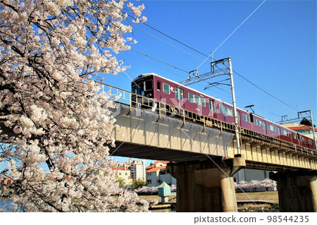 Hankyu train crossing Takarazuka Bridge and cherry blossoms Hankyu train crossing Takarazuka Bridge and cherry blossoms 98544235