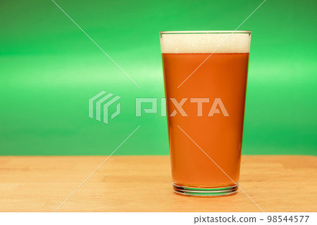 Full shaker pint glass of ale or beer on a table Full shaker pint glass of ale or beer on a table 98544577