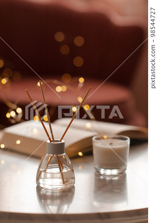 Home liquid fragrance with candles on table in room 98544727