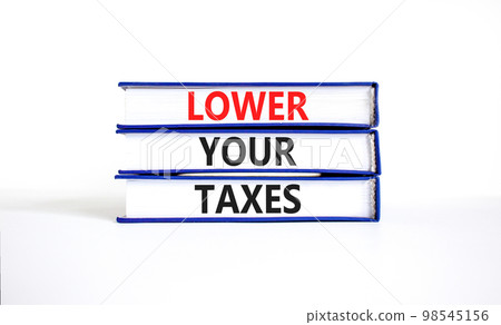 Lower your taxes symbol. Concept words Lower your taxes on books on a beautiful white table white background. Business tax lower your taxes concept. Copy space. Lower your taxes symbol. Concept words Lower your taxes on books on a beautiful white table white background. Business tax lower your taxes concept. Copy space. 98545156