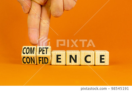 Competence and confidence symbol. Concept word Competence Confidence on wooden cubes. Businessman hand. Beautiful orange table orange background. Business competence confidence concept. Copy space. 98545191