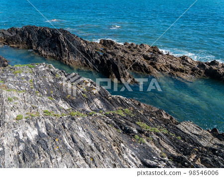 Picturesque cliffs in blue sea water. Seaside landscape. Blue sea beside rock Picturesque cliffs in blue sea water. Seaside landscape. Blue sea beside rock 98546006