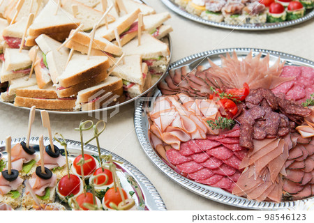 The buffet at the reception. Assortment of canapes. Banquet service. Catering, snacks with different types of cheese and meat. Party Concept. The buffet at the reception. Assortment of canapes. Banquet service. Catering, snacks with different types of cheese and meat. Party Concept. 98546123