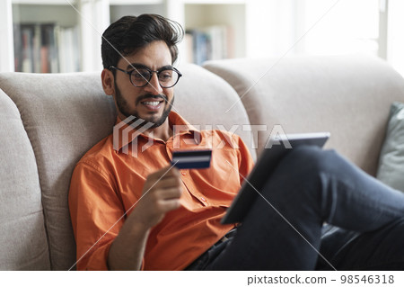Positive arabic guy enjoying newest banking mobile app on pad 98546318