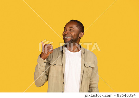 Happy surprised middle aged african american man in casual showing thumb up to back on copy space 98546354