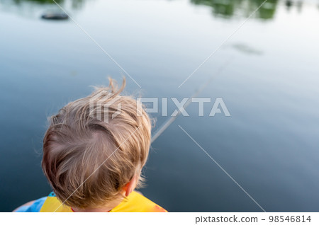 Boy on a fishing with blue water in background Boy on a fishing with blue water in background 98546814