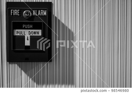 Selective focus on a wall mounted fire alarm switch in a empty hallway 98546980