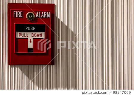 Selective focus on a wall mounted fire alarm switch in a empty hallway 98547009