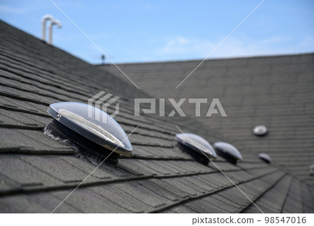 Dome shaped solar tube skylight on asphalt shingle roof Dome shaped solar tube skylight on asphalt shingle roof 98547016