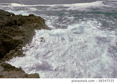 Waves breaking on the rocks at the shore of the beach Waves breaking on the rocks at the shore of the beach 98547535