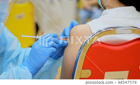 Close-up and selective focus of doctor hands who is vaccinating on upper arm of young woman for build immunity infection corona virus or covid-19 species type beta, alpha, delta and omicron in body 98547578