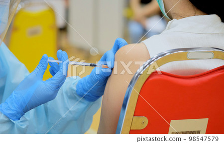 Close-up and selective focus of doctor hands who is vaccinating on upper arm of young woman for build immunity infection corona virus or covid-19 species type beta, alpha, delta and omicron in body 98547579