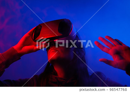 person wearing virtual reality glasses gets experience of gaming and entertainment person wearing virtual reality glasses gets experience of gaming and entertainment 98547768