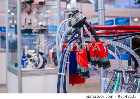 Teat cups of automated cow milking suction machine at exhibition: close up Teat cups of automated cow milking suction machine at exhibition: close up 98548535