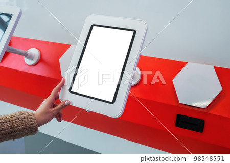 Woman using interactive empty white touchscreen display kiosk at exhibition 98548551
