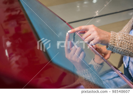 Woman using interactive touchscreen display at modern museum or exhibition Woman using interactive touchscreen display at modern museum or exhibition 98548607