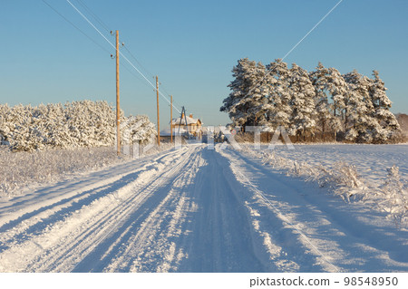 Country road after a snowstorm covered with snow Country road after a snowstorm covered with snow 98548950