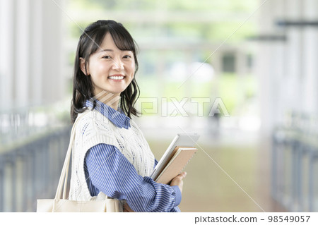 一個年輕的女大學生微笑著看著相機的形象 98549057