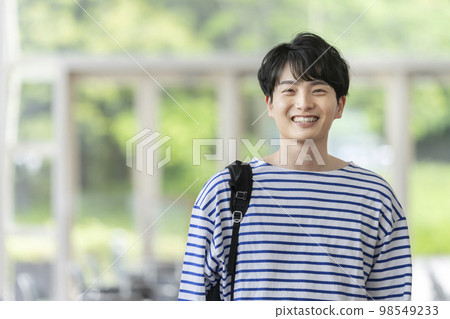 一個背著背包的年輕人看著鏡頭微笑 98549233