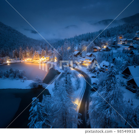 Aerial view of town in snow, road, forest, lake and houses 98549918