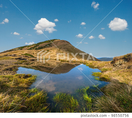 Small picturesque lake with clouds reflections at the  Strymba Mount. Beautiful autumn day in Carpathian Mountains near Kolochava village, Transcarpathia, Ukraine. 98550756
