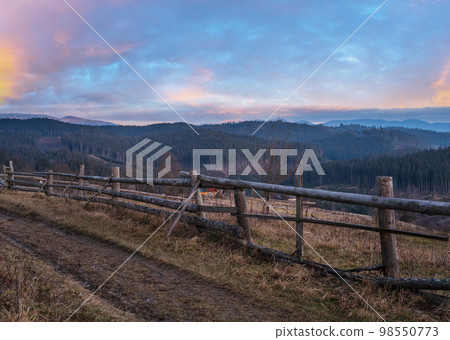 Picturesque pre sunrise morning above late autumn mountain countryside. Ukraine, Carpathian Mountains, Petros top in far. Peaceful traveling, seasonal, nature and countryside beauty concept scene. Picturesque pre sunrise morning above late autumn mountain countryside. Ukraine, Carpathian Mountains, Petros top in far. Peaceful traveling, seasonal, nature and countryside beauty concept scene. 98550773
