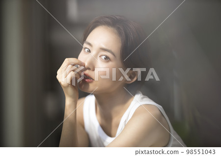 Woman by the window Woman by the window 98551043