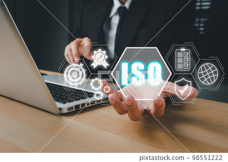 ISO standards quality control concept, Person hand holding iso icon on virtual screen on desk workplace, Assurance warranty, Business technology concept. ISO standards quality control concept, Person hand holding iso icon on virtual screen on desk workplace, Assurance warranty, Business technology concept. 98551222