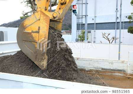 A bucket that loads dirt into a dump 98551565