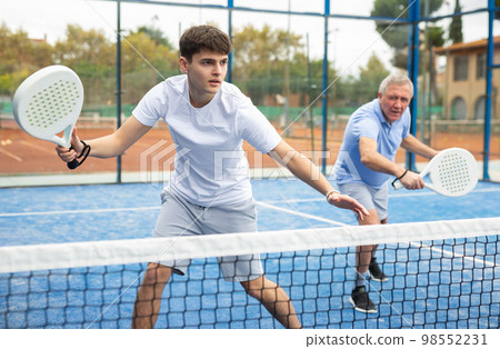 Man in sportswear playing padel tennis match during training on court 98552231