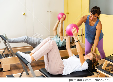 Teenagers training pilates in gym with trainer Teenagers training pilates in gym with trainer 98552560