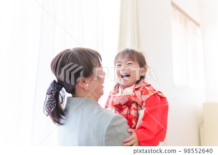 A mother hugging a girl wearing a Shichigosan kimono A mother hugging a girl wearing a Shichigosan kimono 98552640