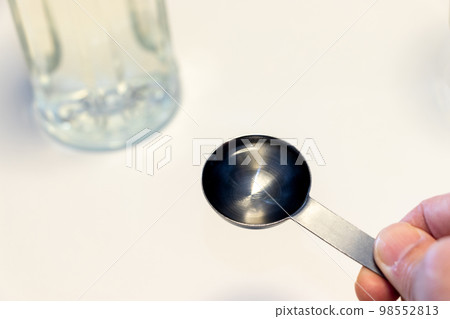 Measure the amount of seasoning with a measuring spoon 98552813