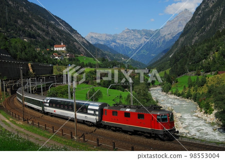 A train of the Swiss Federal Railways crossing the Gotthard Pass with the church of Wassen in the background A train of the Swiss Federal Railways crossing the Gotthard Pass with the church of Wassen in the background 98553004